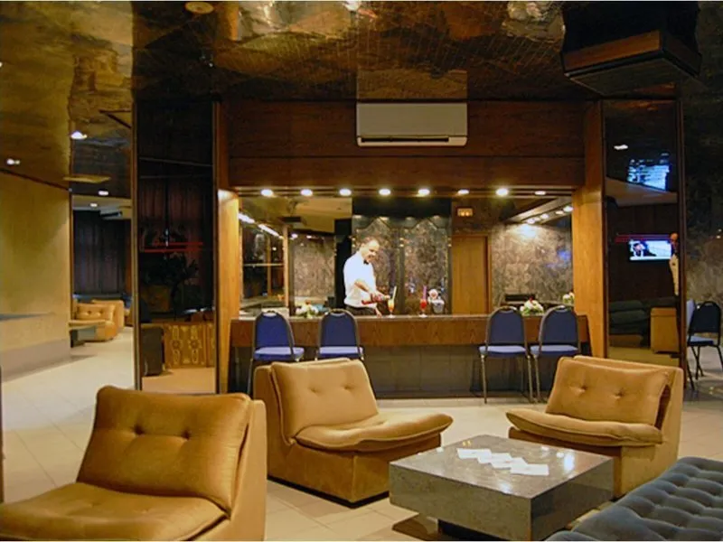 Elegantna hotelska avla z marmornimi detajli in udobnimi naslanjači