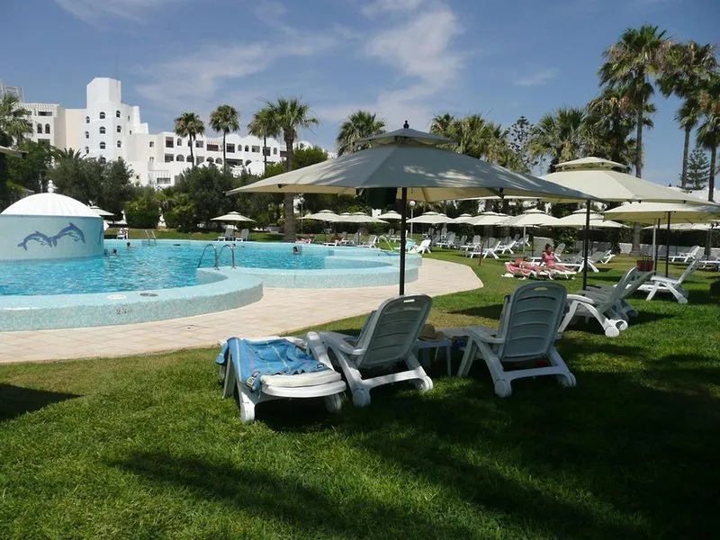 Prostoren zunanji bazen z belimi ležalniki