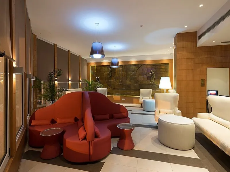 Sodoben lobi hotela z rdečimi in belimi dizajnerskimi naslanjači