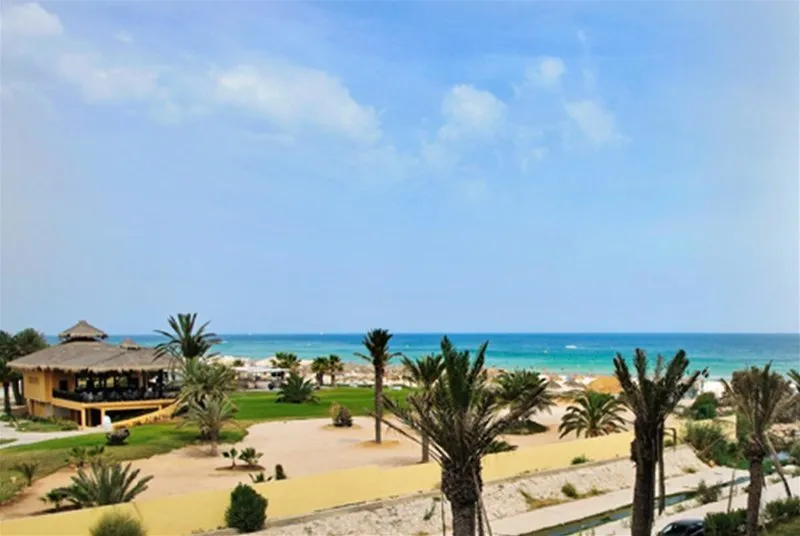 Peščena plaža s slamnatimi senčniki pred hotelom