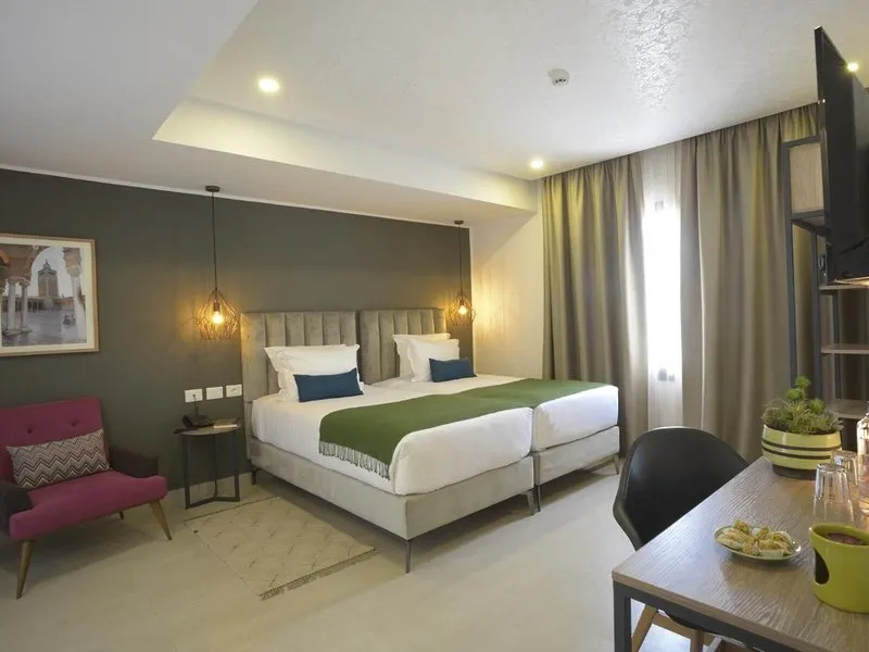 Elegantna spalnica z zakonsko posteljo in zeleno dekoracijo