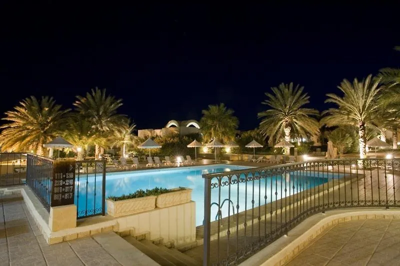 Zunanji bazen hotela Ras El Ain obdan s palmami ponoči
