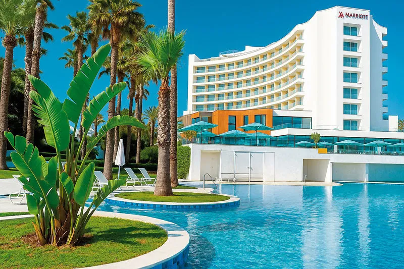 Zunanjost hotela Sousse Pearl Marriott z bazenom in palmami
